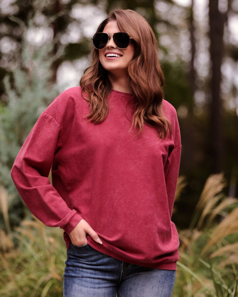 a long-sleeve ribbed textured pullover with a crew neck collar, a vintage wash, and a relaxed fit in red