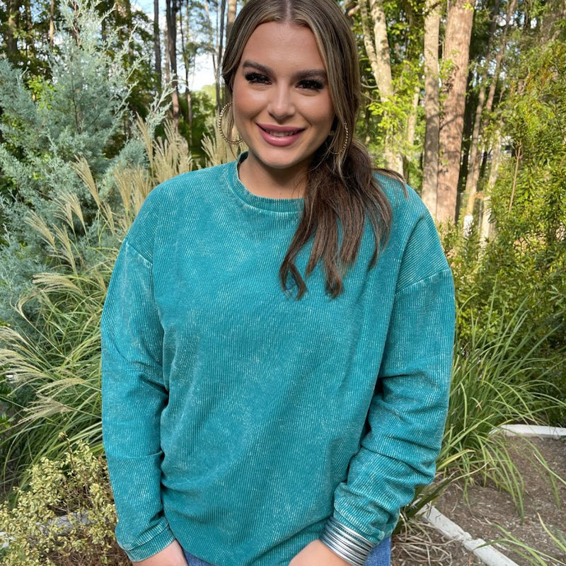 a long-sleeve ribbed textured pullover with a crew neck collar, a vintage wash, and a relaxed fit in teal
