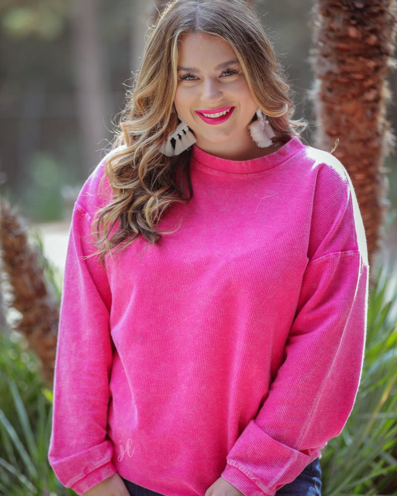 a long-sleeve ribbed textured pullover with a crew neck collar, a vintage wash, and a relaxed fit in pink