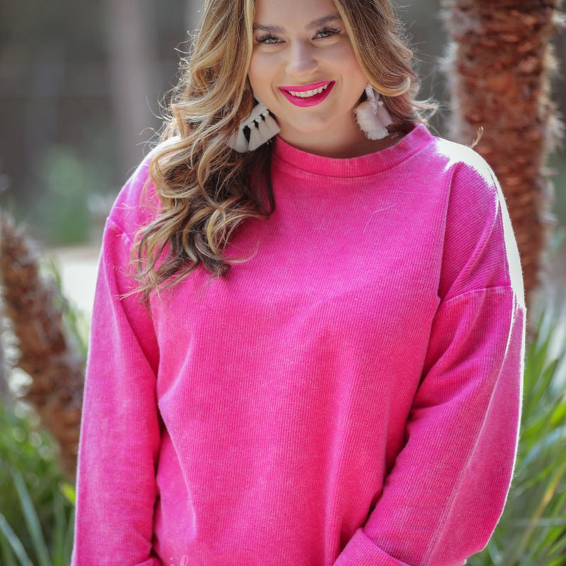 a long-sleeve ribbed textured pullover with a crew neck collar, a vintage wash, and a relaxed fit in pink