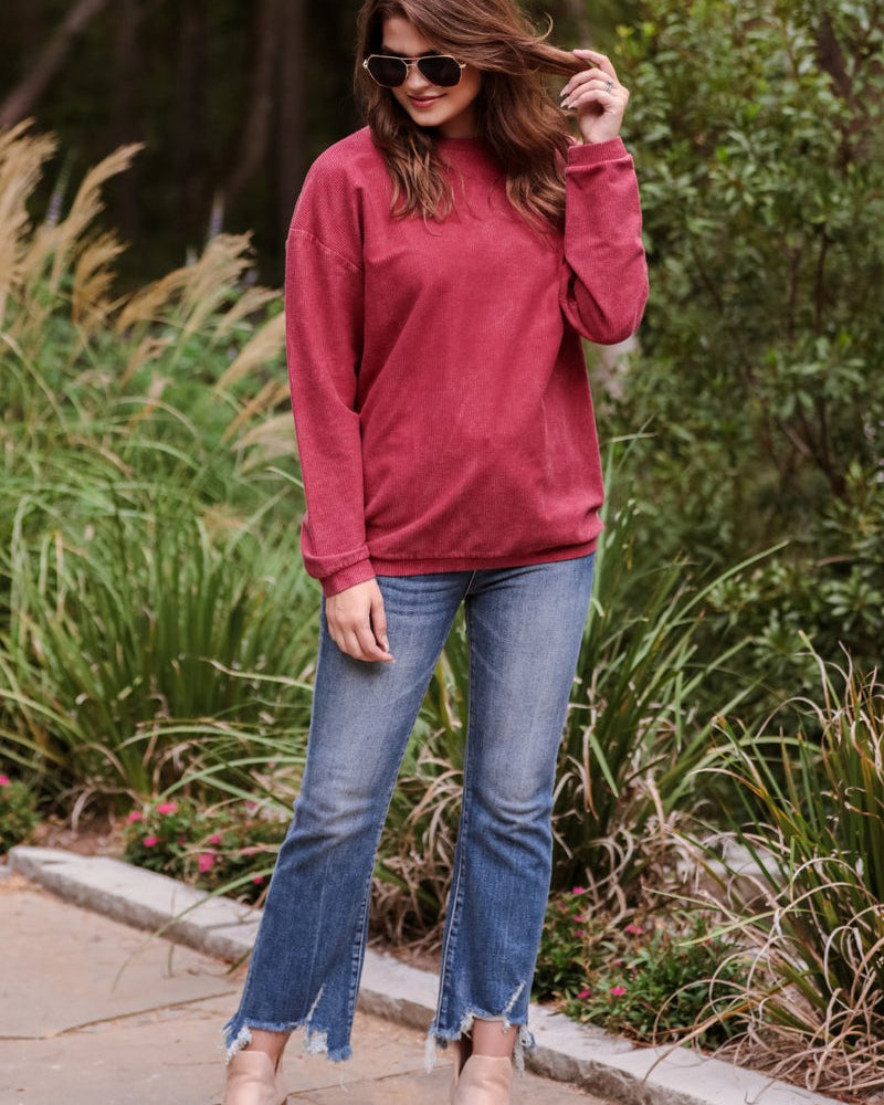 a long-sleeve ribbed textured pullover with a crew neck collar, a vintage wash, and a relaxed fit in red