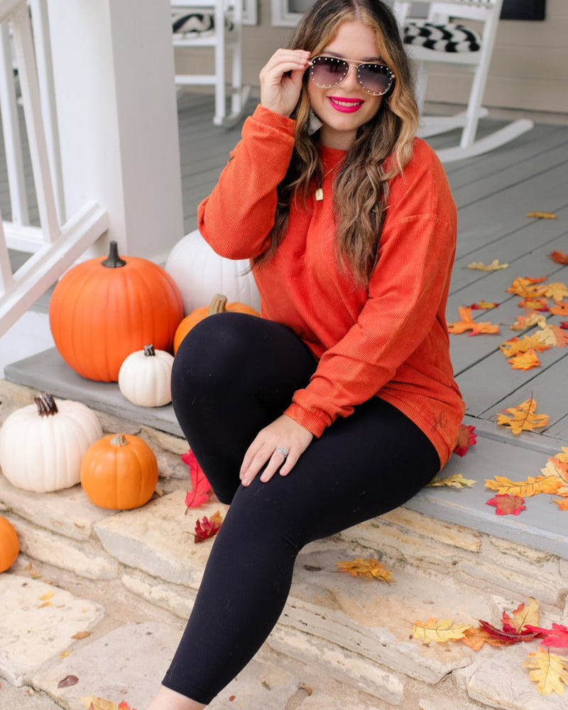 a long-sleeve ribbed textured pullover with a crew neck collar, a vintage wash, and a relaxed fit in rust