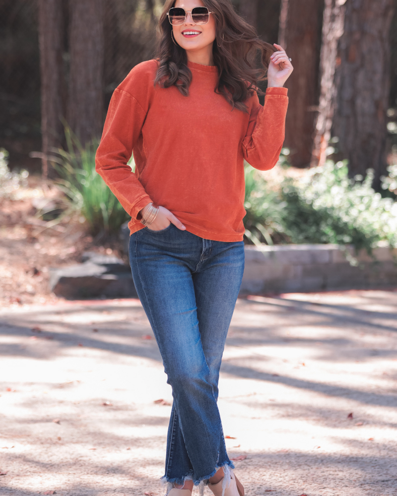 a long-sleeve ribbed textured pullover with a crew neck collar, a vintage wash, and a relaxed fit in rust