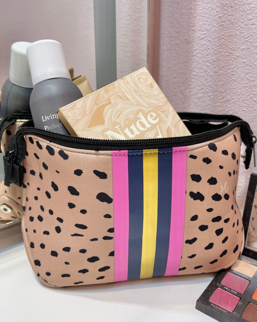 neoprene cosmetic bag in a classic animal print with dual top zippers (black), expandable side snaps (silver), and racing stripes (gold, navy, and pink)