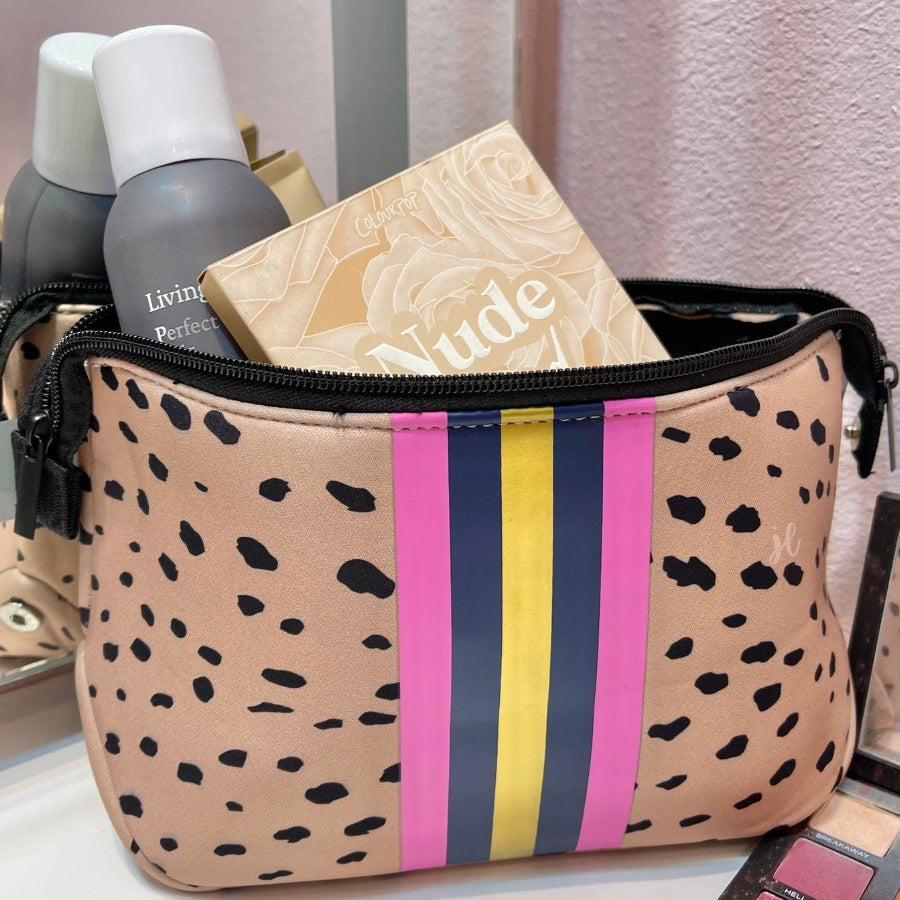 neoprene cosmetic bag in a classic animal print with dual top zippers (black), expandable side snaps (silver), and racing stripes (gold, navy, and pink)