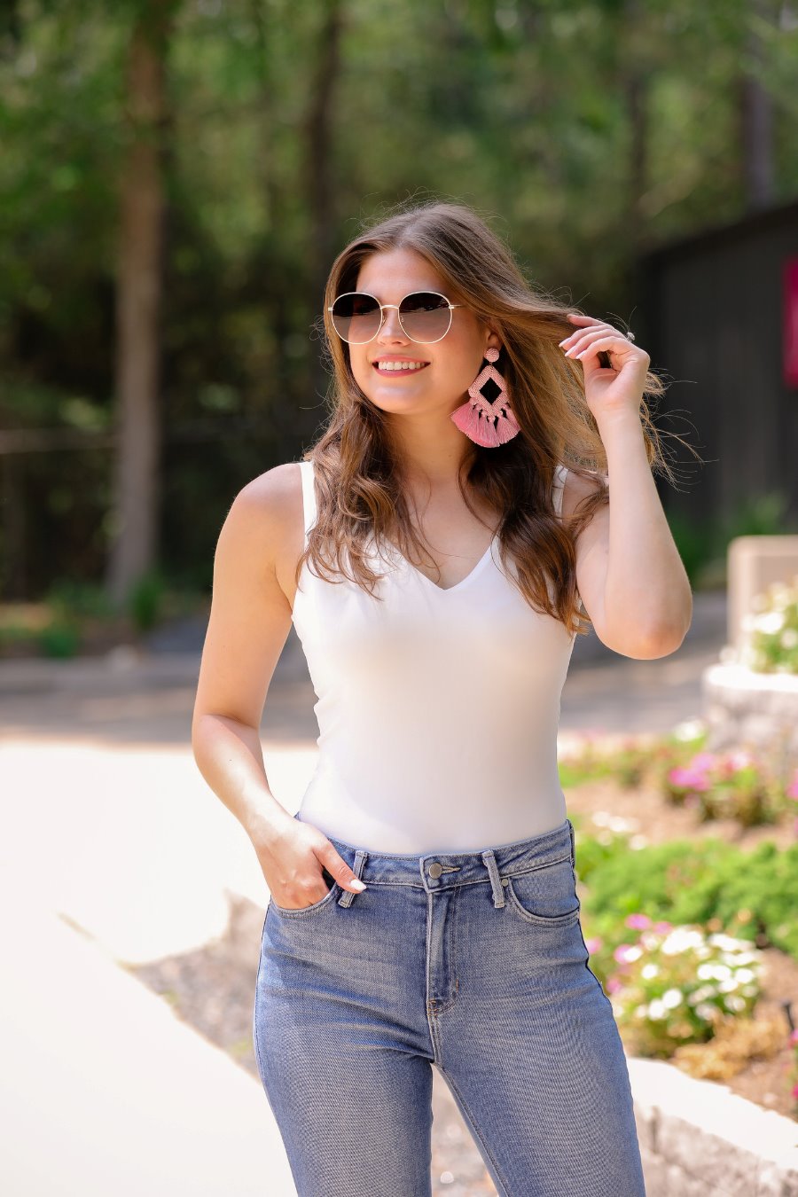 one-piece bodysuit made of soft and stretchy lightweight material with a v-neckline, sleeveless shoulder straps with a racerback fit, and a form-fitting silhouette that falls into a cheeky fit with a snap button closure in ivory