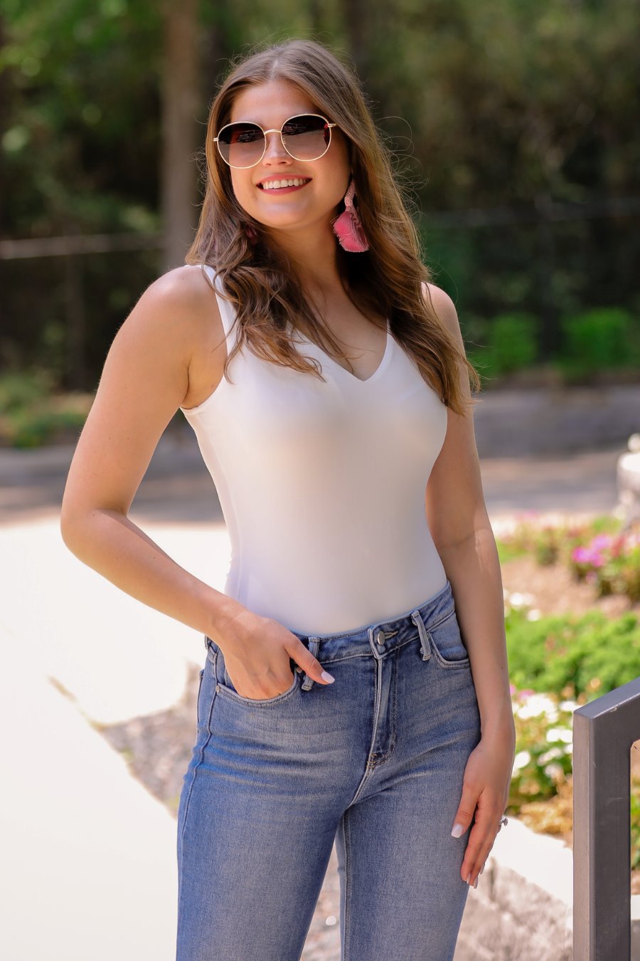 one-piece bodysuit made of soft and stretchy lightweight material with a v-neckline, sleeveless shoulder straps with a racerback fit, and a form-fitting silhouette that falls into a cheeky fit with a snap button closure in ivory