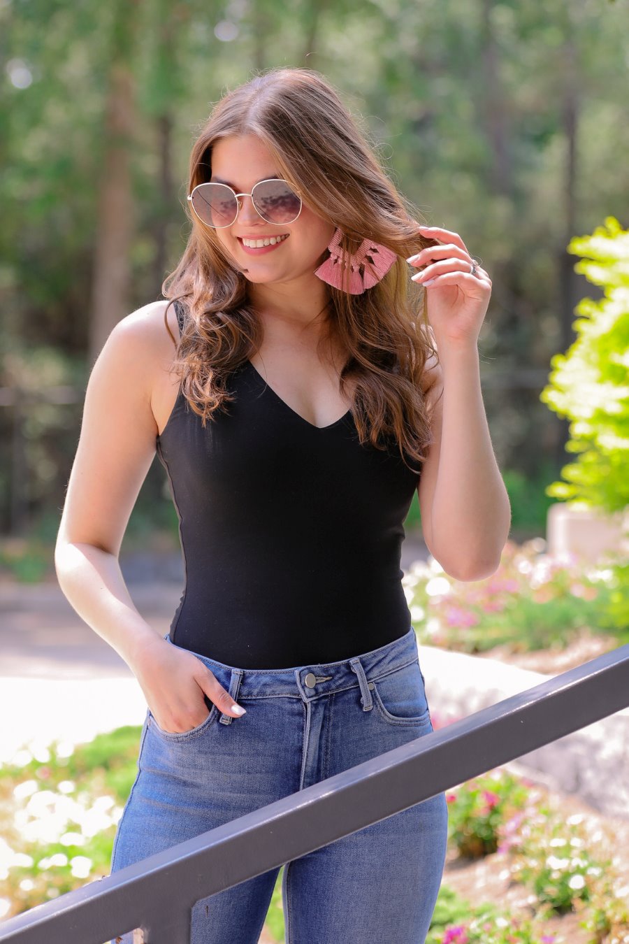 one-piece bodysuit made of soft and stretchy lightweight material with a v-neckline, sleeveless shoulder straps with a racerback fit, and a form-fitting silhouette that falls into a cheeky fit with a snap button closure in black