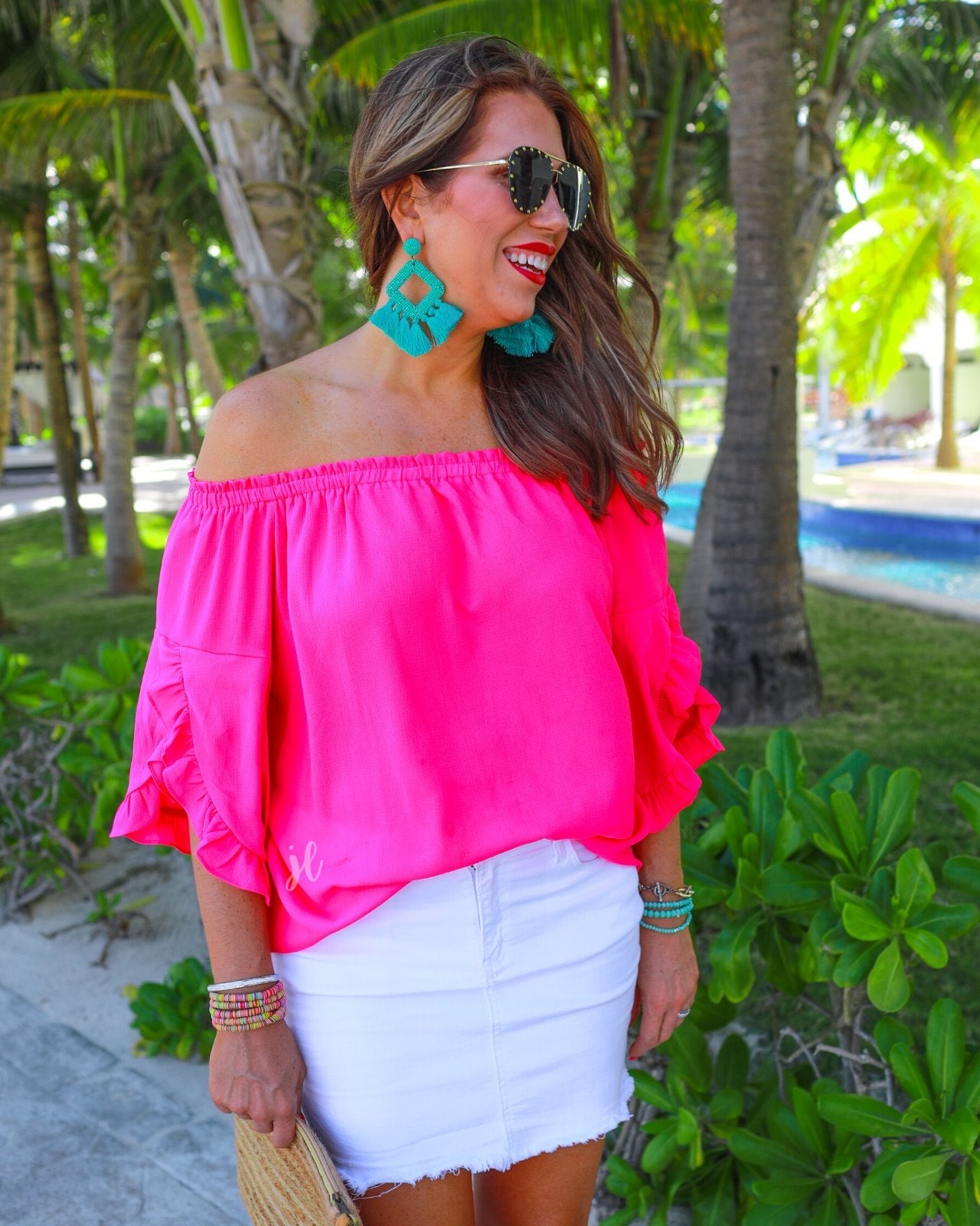 a flowy style top with a gathered scoop neckline that can be worn on or off the shoulder and three-quarter split ruffle sleeves in pink