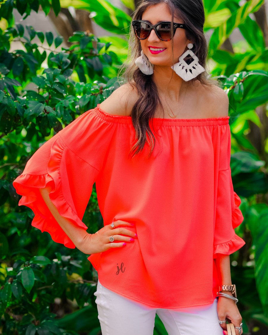 a flowy style top with a gathered scoop neckline that can be worn on or off the shoulder and three-quarter split ruffle sleeves in coral
