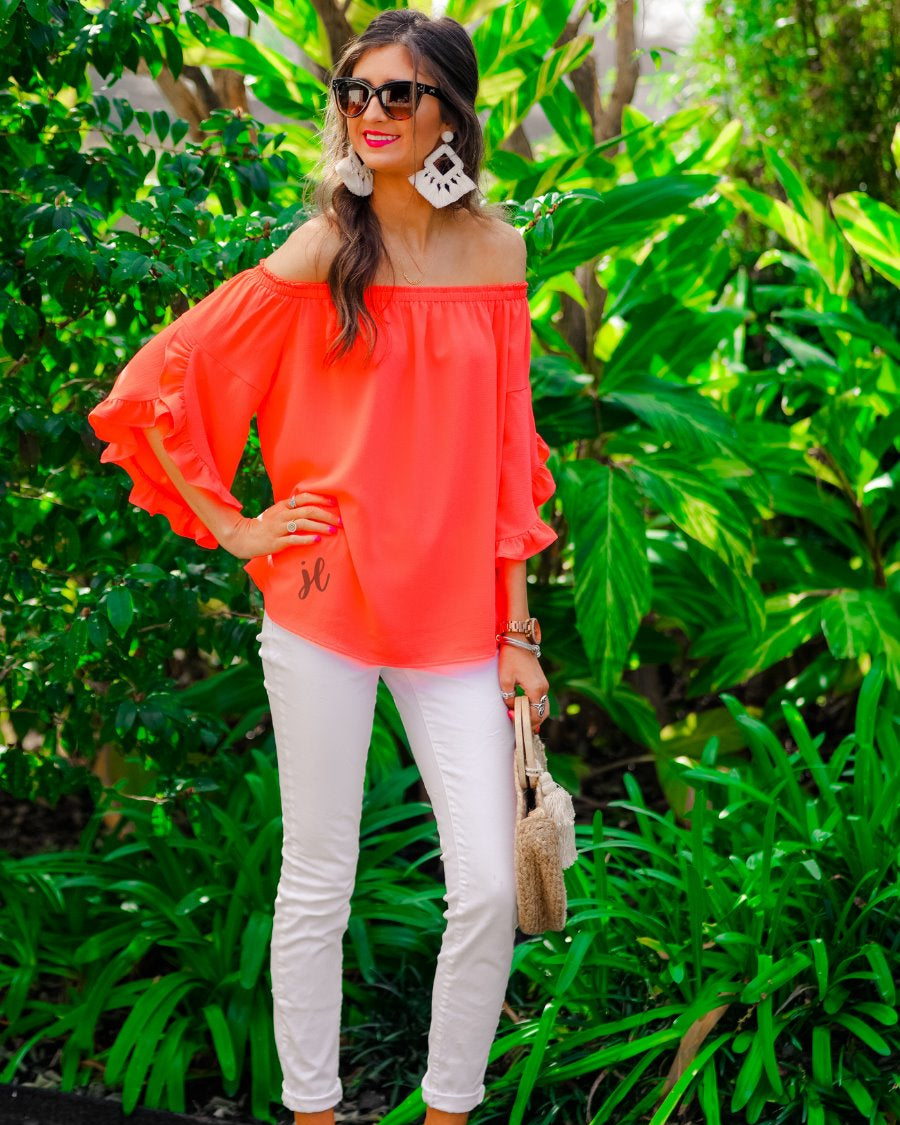 a flowy style top with a gathered scoop neckline that can be worn on or off the shoulder and three-quarter split ruffle sleeves in coral