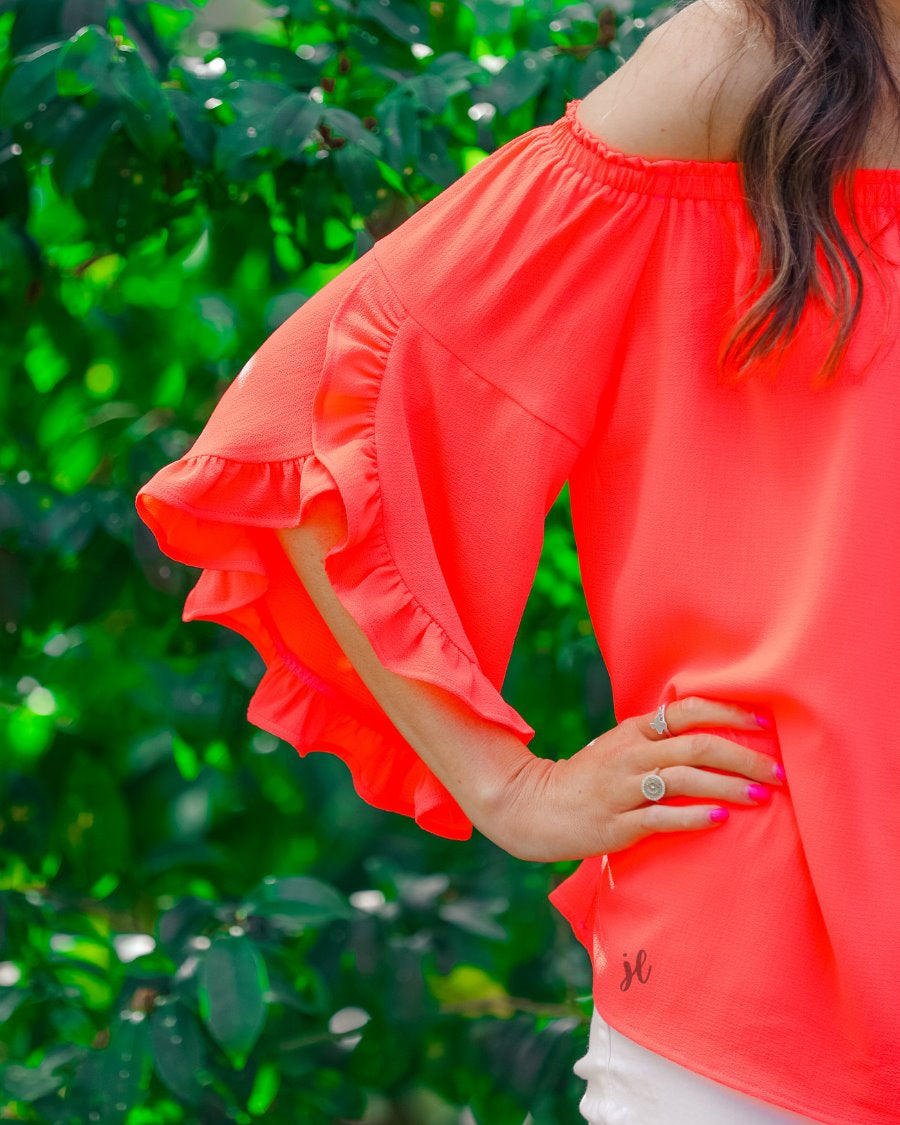 a flowy style top with a gathered scoop neckline that can be worn on or off the shoulder and three-quarter split ruffle sleeves in coral