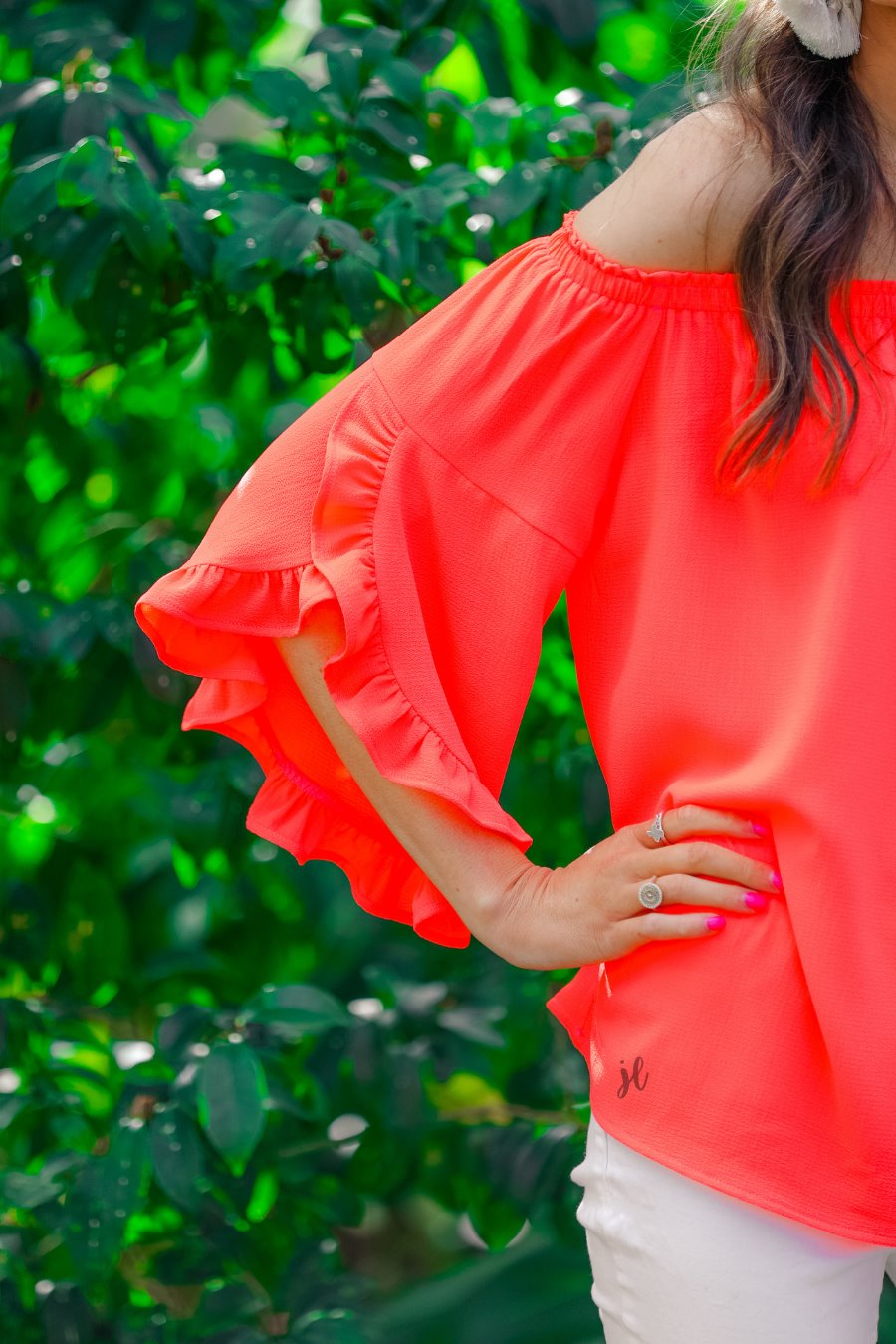 a flowy style top with a gathered scoop neckline that can be worn on or off the shoulder and three-quarter split ruffle sleeves in coral