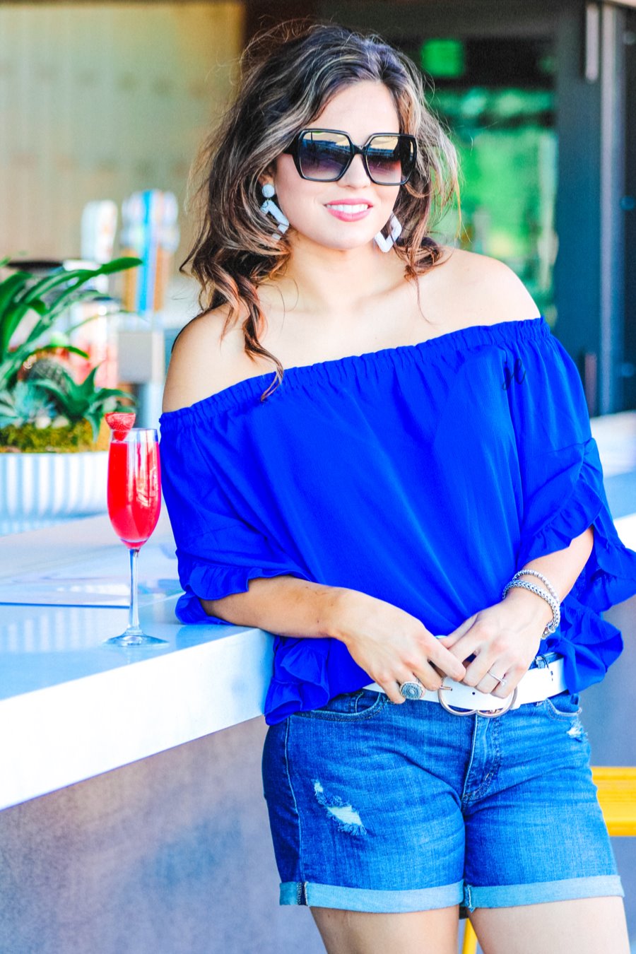 a flowy style top with a gathered scoop neckline that can be worn on or off the shoulder and three-quarter split ruffle sleeves in blue
