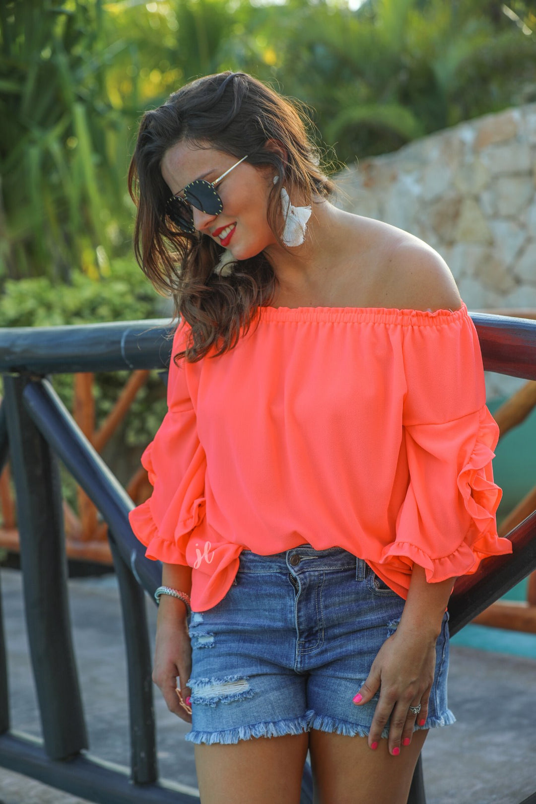 a flowy style top with a gathered scoop neckline that can be worn on or off the shoulder and three-quarter split ruffle sleeves in coral