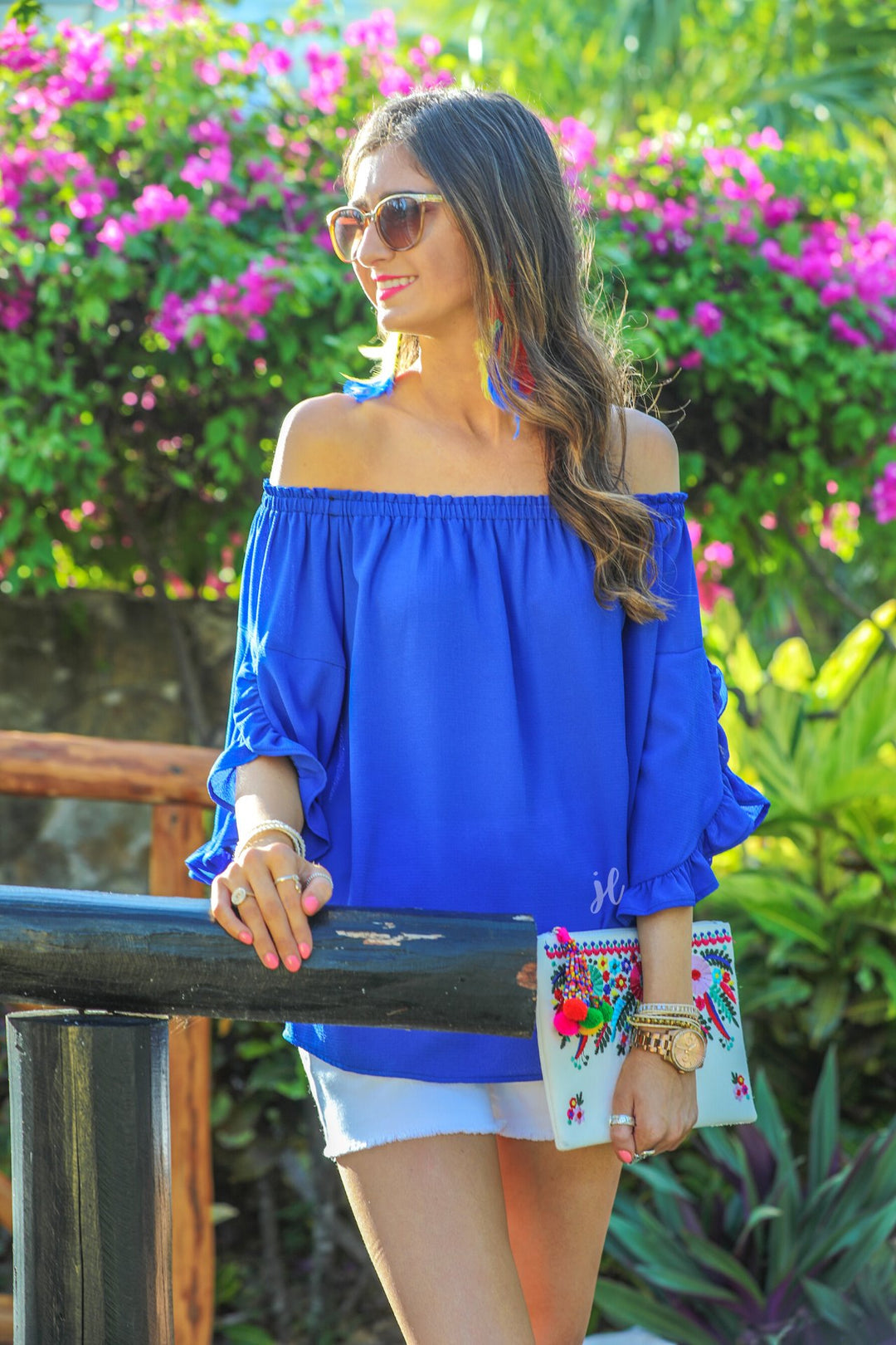 a flowy style top with a gathered scoop neckline that can be worn on or off the shoulder and three-quarter split ruffle sleeves in blue
