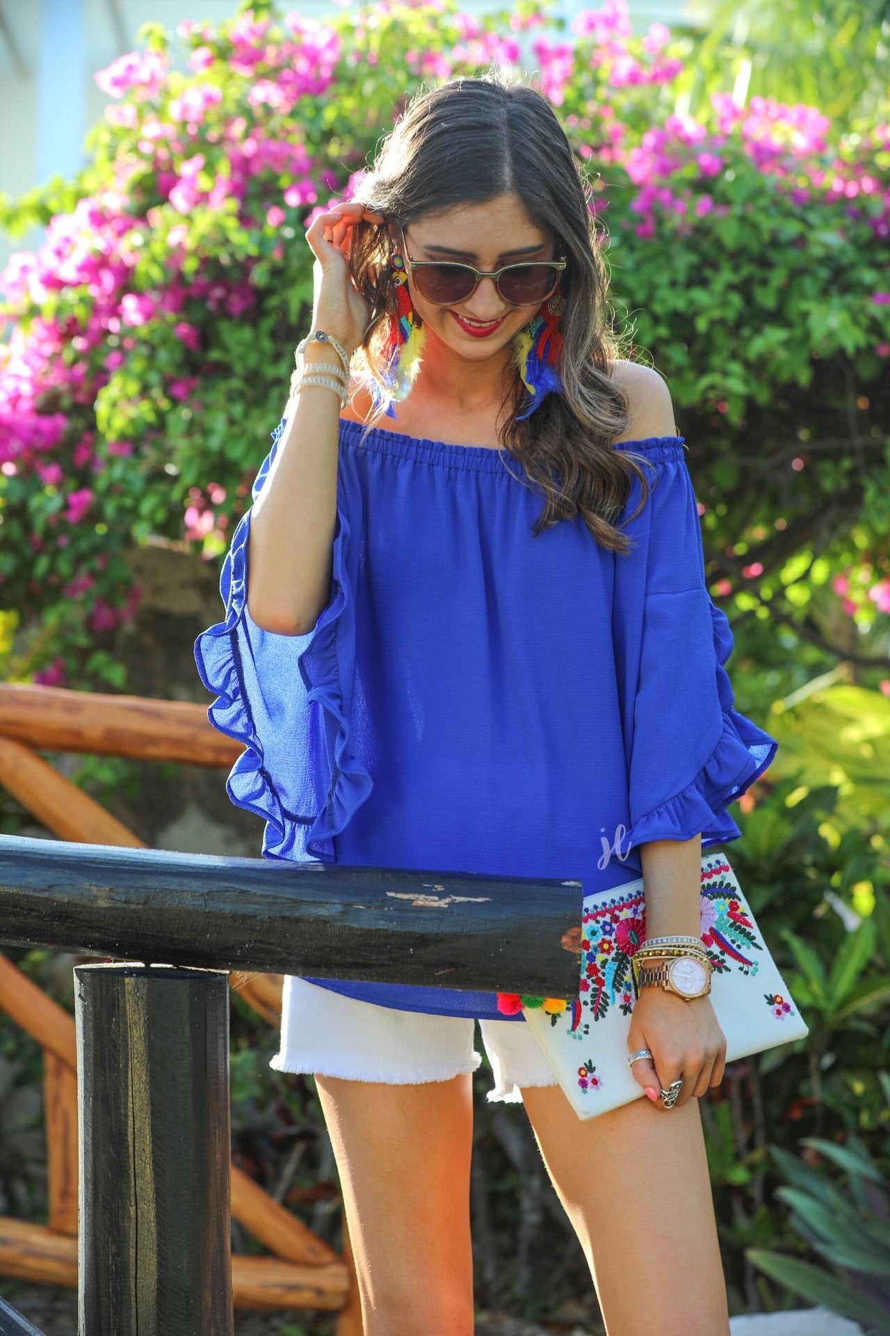 a flowy style top with a gathered scoop neckline that can be worn on or off the shoulder and three-quarter split ruffle sleeves in blue