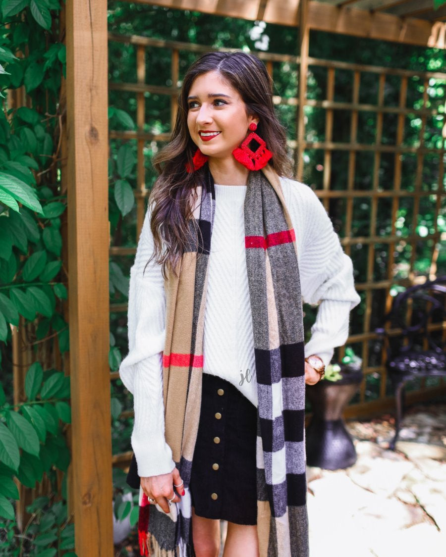 a white long-sleeve sweater with a textured cable knit front and sleeves, balanced by a smooth back panel, a relaxed drop-shoulder silhouette, and ribbed detailing on classic crew neckline, cuffs, and hem