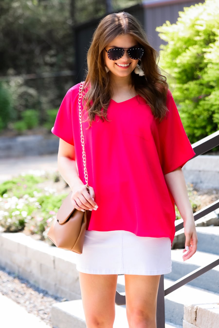 a lightweight magenta short-sleeve woven tunic with a V-neckline, a front chest pocket, and a relaxed, non-stretch silhouette