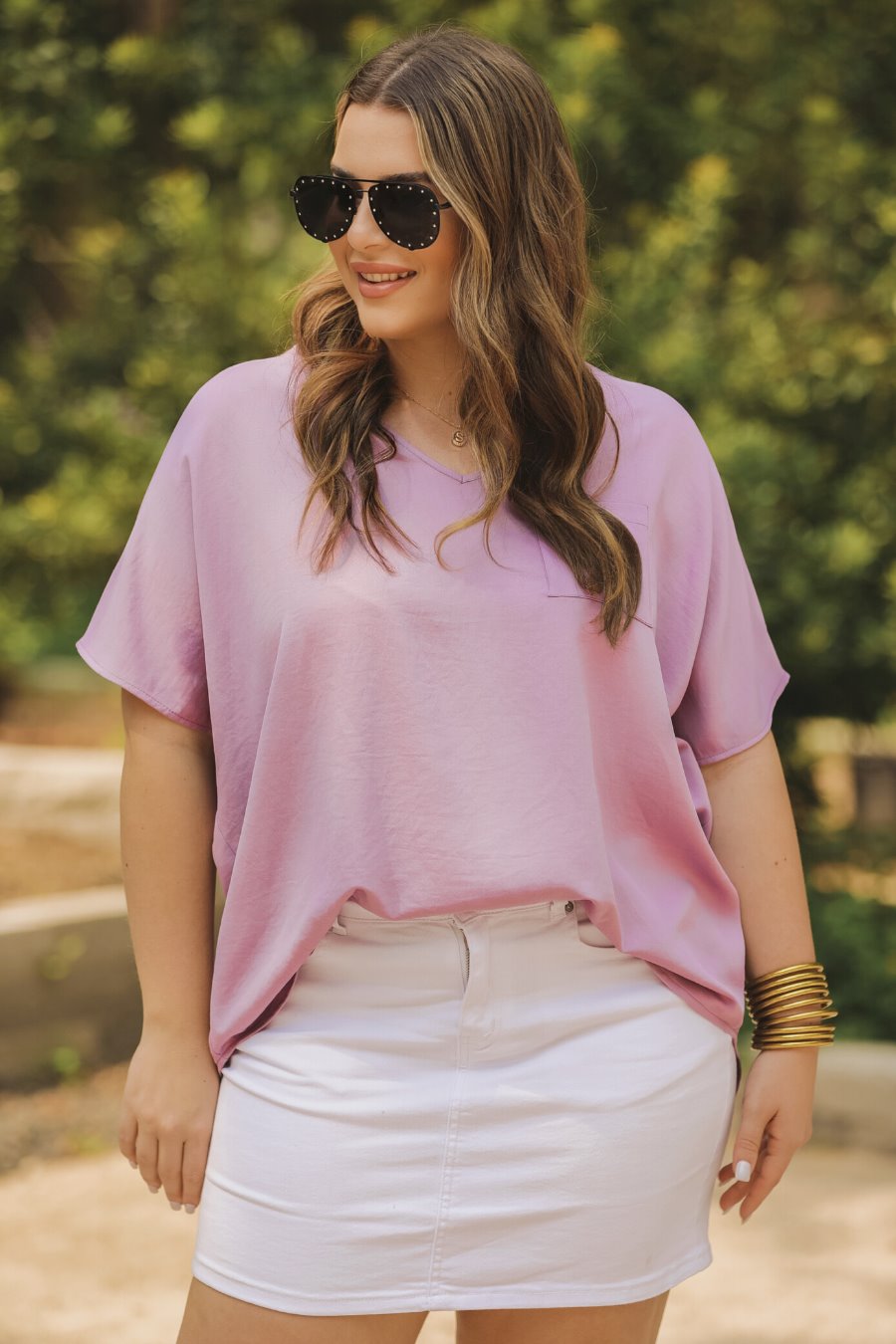 a lightweight lilac short-sleeve woven tunic with a V-neckline, a front chest pocket, and a relaxed, non-stretch silhouette