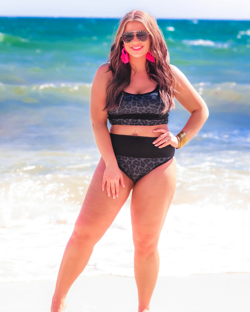 two-piece bikini swimsuit with a scoop neck, adjustable spaghetti straps, and removable padding paired with a full-coverage banded high-waist bottoms on a black leopard print fabric