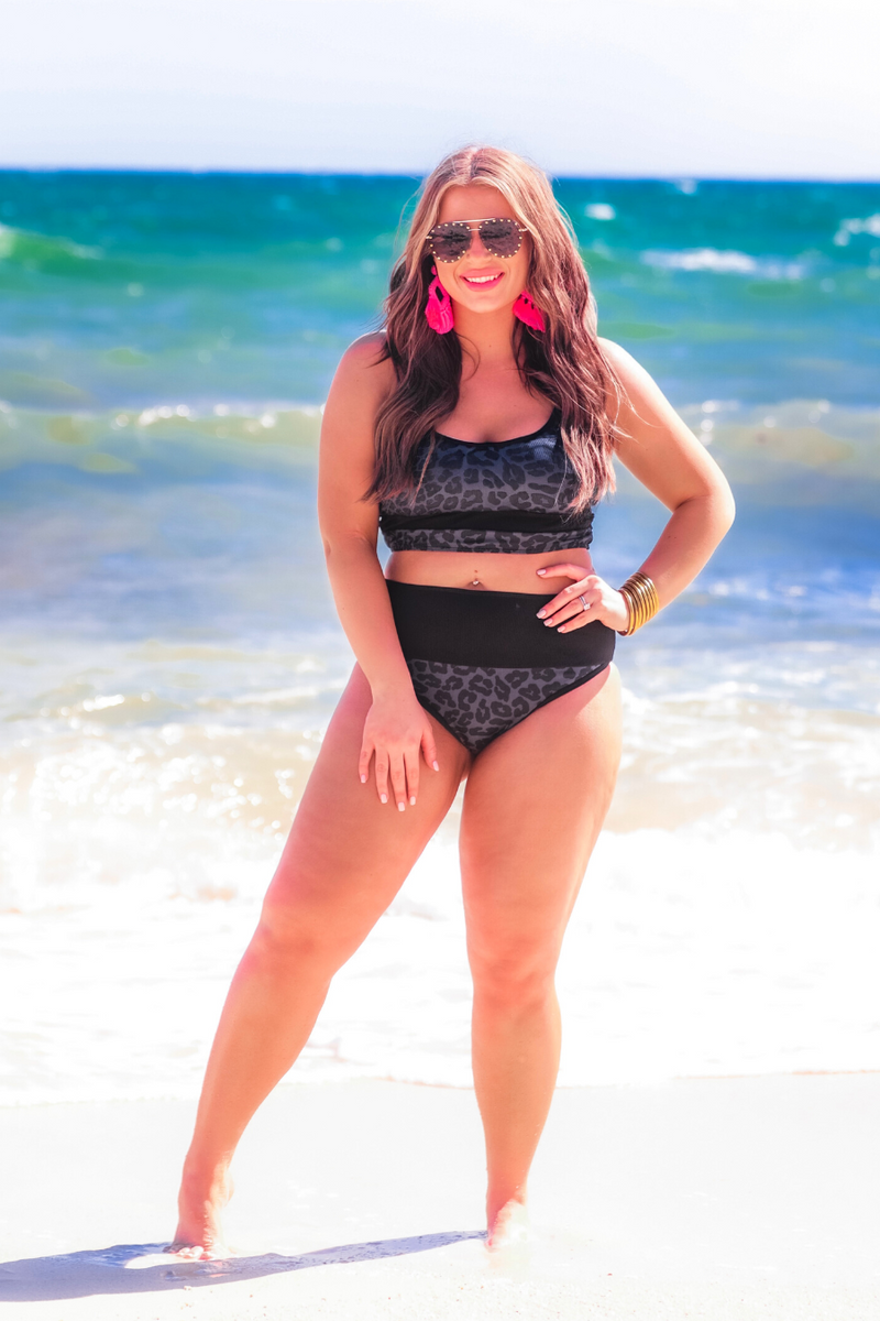 two-piece bikini swimsuit with a scoop neck, adjustable spaghetti straps, and removable padding paired with a full-coverage banded high-waist bottoms on a black leopard print fabric