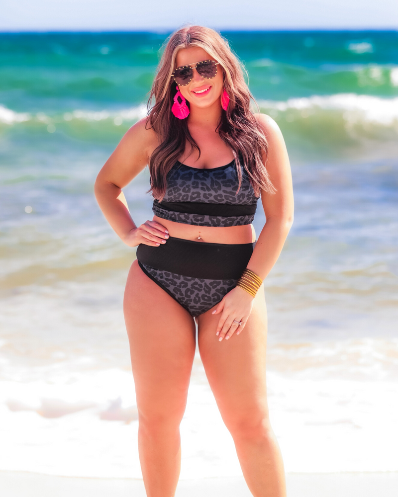 two-piece bikini swimsuit with a scoop neck, adjustable spaghetti straps, and removable padding paired with a full-coverage banded high-waist bottoms on a black leopard print fabric
