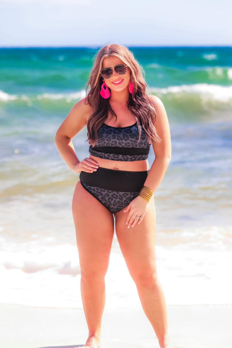 two-piece bikini swimsuit with a scoop neck, adjustable spaghetti straps, and removable padding paired with a full-coverage banded high-waist bottoms on a black leopard print fabric