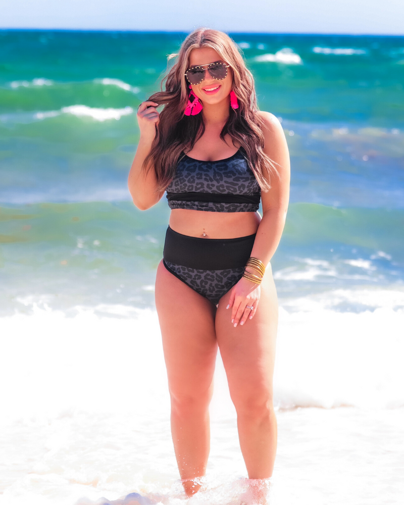 two-piece bikini swimsuit with a scoop neck, adjustable spaghetti straps, and removable padding paired with a full-coverage banded high-waist bottoms on a black leopard print fabric