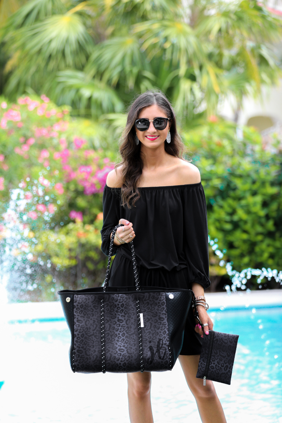 ultra-lightweight tote made of neoprene with a removable hard bottom liner, paracord shoulder straps, removable matching zippered pouch, magnetic side snap closures in silver hardware, and black interior (tote and pouch) on a black on black leopard print pattern