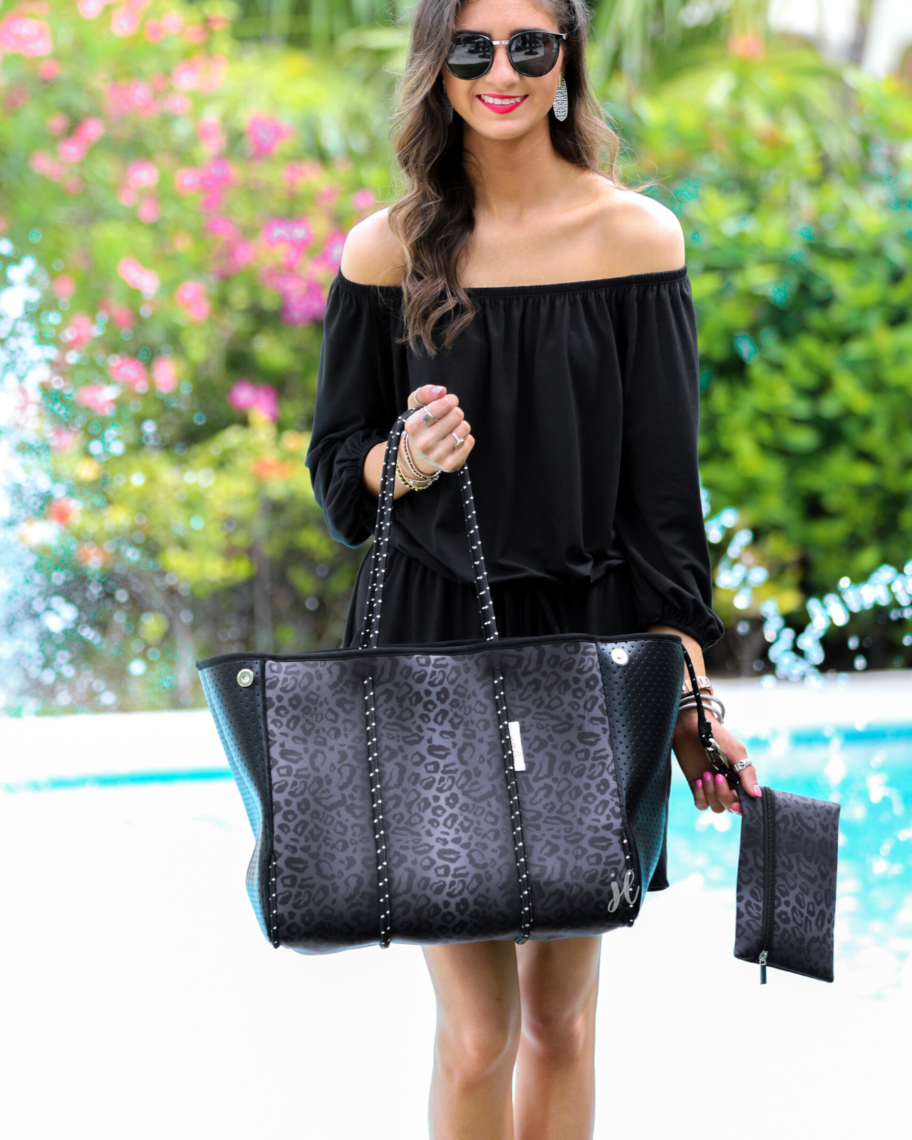 ultra-lightweight tote made of neoprene with a removable hard bottom liner, paracord shoulder straps, removable matching zippered pouch, magnetic side snap closures in silver hardware, and black interior (tote and pouch) on a black on black leopard print pattern