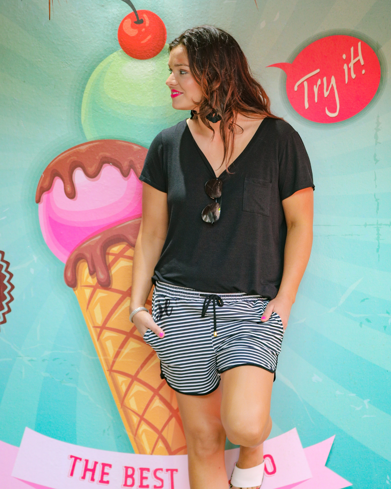 mid-rise relaxed fit activewear shorts with side pockets and a tie waist drawstring with gold bead accents, designed on a black and white horizontal stripe pattern print fabric and black trim