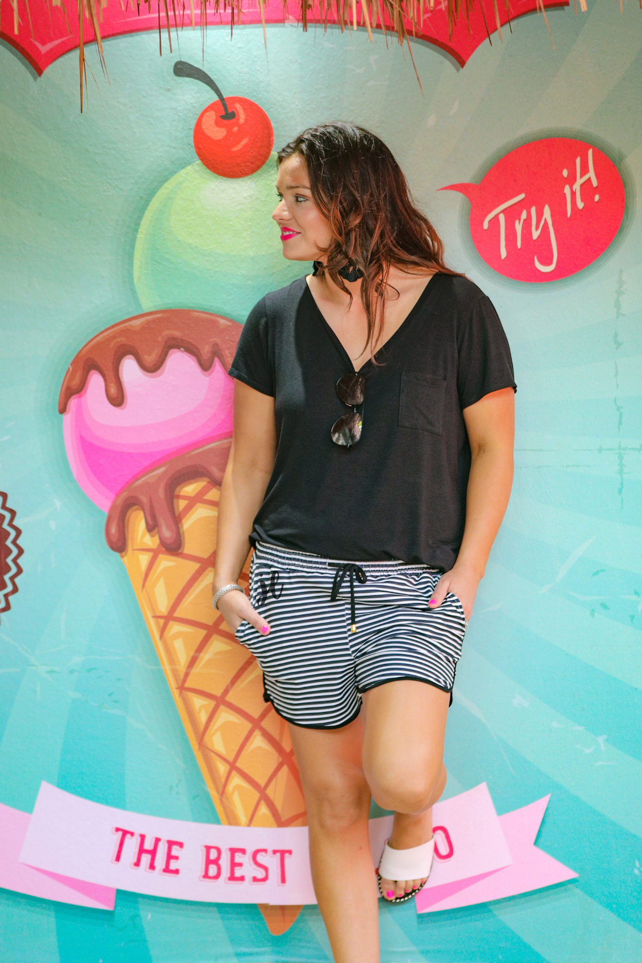 mid-rise relaxed fit activewear shorts with side pockets and a tie waist drawstring with gold bead accents, designed on a black and white horizontal stripe pattern print fabric and black trim