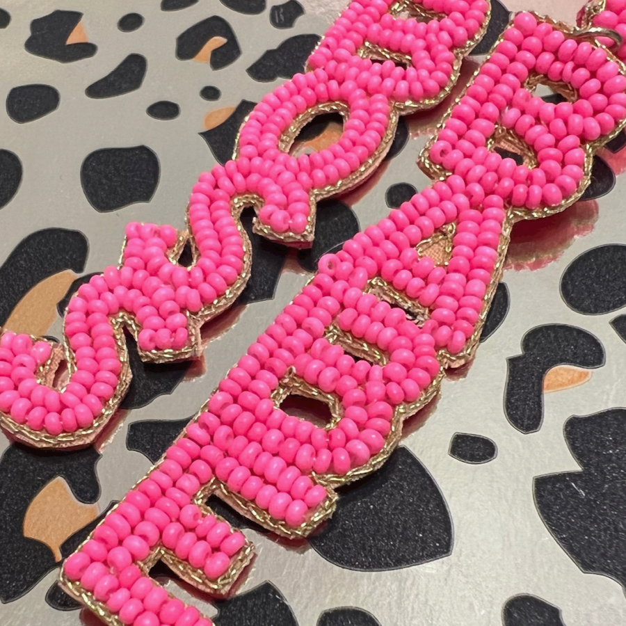 ultra-lightweight hot pink outlined in gold word drop statement earrings highlighting the phrase BOSS (right) and BABE (left) with a post stud, felt backing, comfort replacement backs, and gold-tone plastic disk stopper