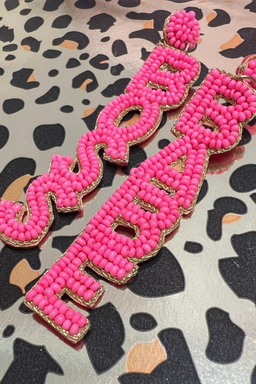 ultra-lightweight hot pink outlined in gold word drop statement earrings highlighting the phrase BOSS (right) and BABE (left) with a post stud, felt backing, comfort replacement backs, and gold-tone plastic disk stopper