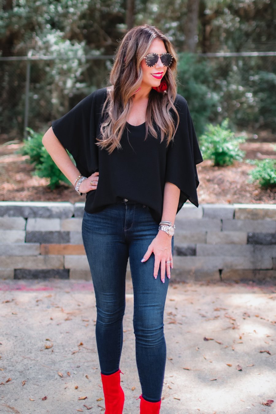 a black v-neck blouses crafted from lightweight textured fabric with asymmetrical half-flutter sleeves, front lining, and a relaxed fit