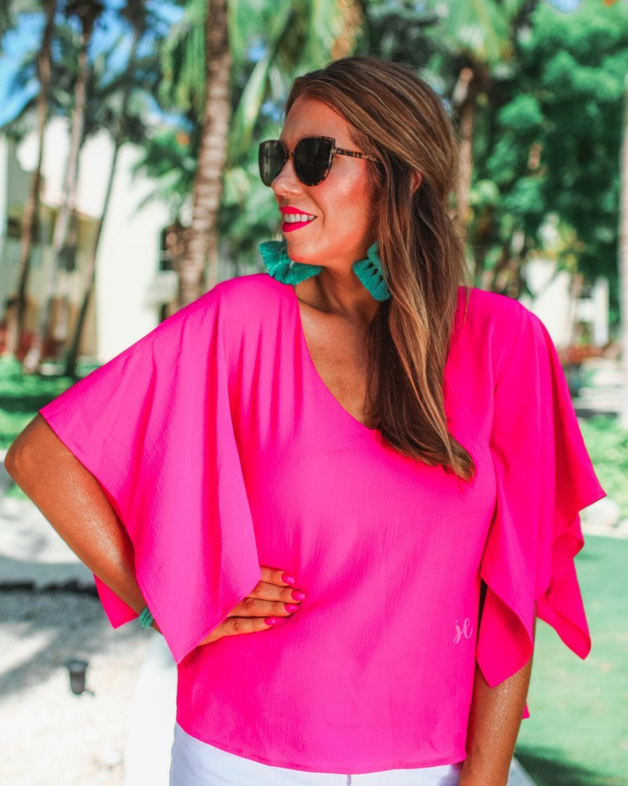 a pink v-neck blouses crafted from lightweight textured fabric with asymmetrical half-flutter sleeves, front lining, and a relaxed fit