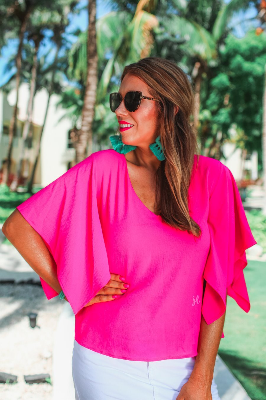 a pink v-neck blouses crafted from lightweight textured fabric with asymmetrical half-flutter sleeves, front lining, and a relaxed fit