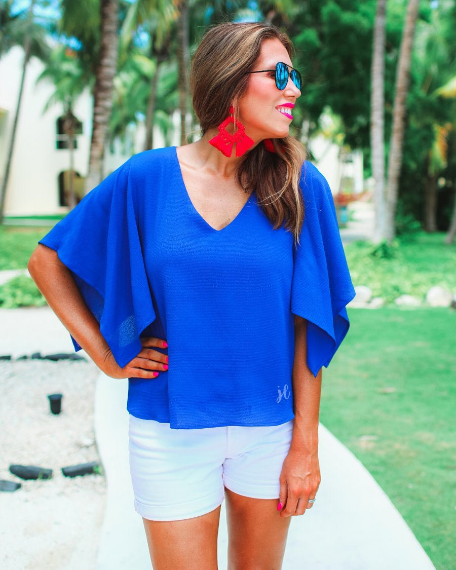 a blue v-neck blouses crafted from lightweight textured fabric with asymmetrical half-flutter sleeves, front lining, and a relaxed fit
