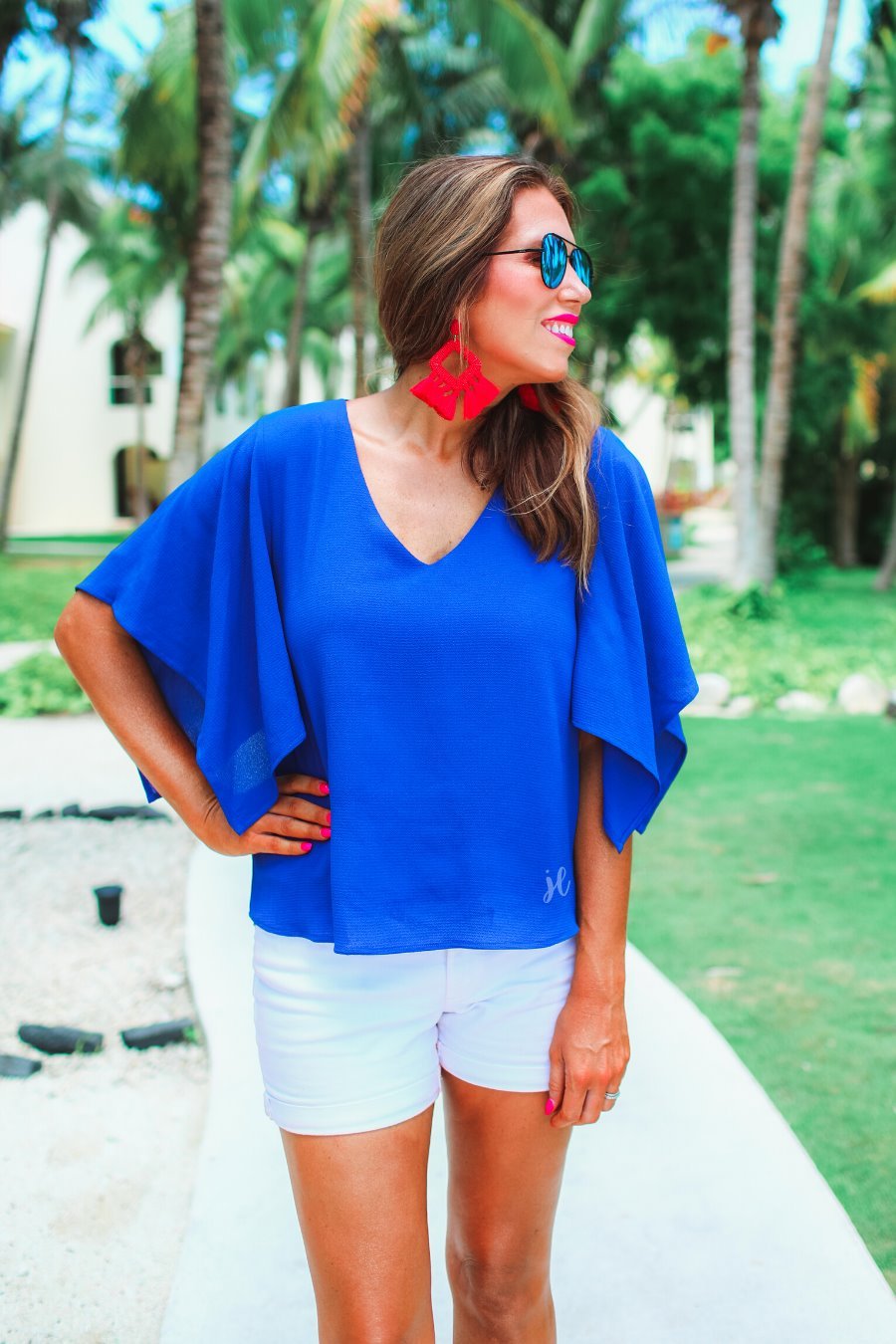 a blue v-neck blouses crafted from lightweight textured fabric with asymmetrical half-flutter sleeves, front lining, and a relaxed fit