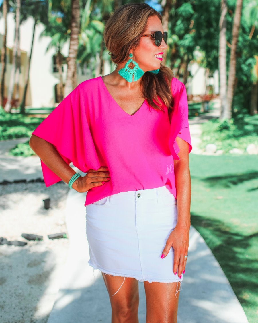 a pink v-neck blouses crafted from lightweight textured fabric with asymmetrical half-flutter sleeves, front lining, and a relaxed fit