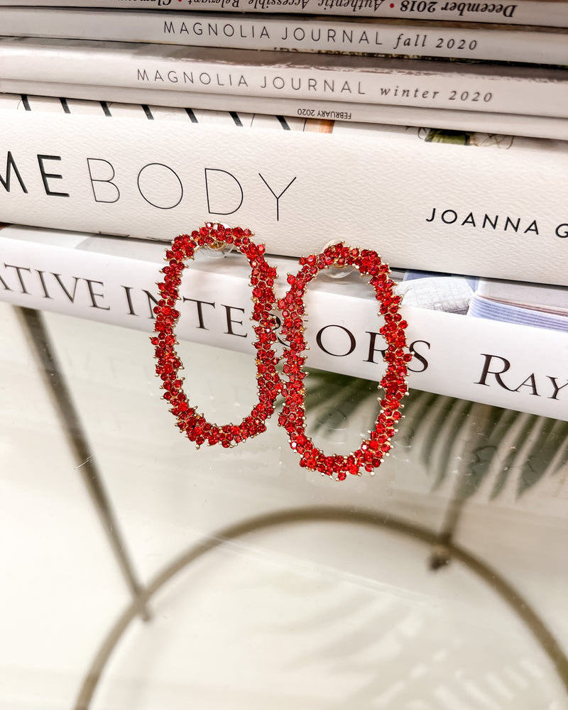 gold cubic zirconia earrings secured with a push backing in a long oval shape in red