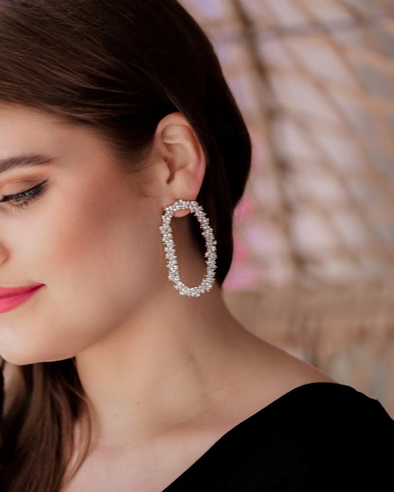 gold cubic zirconia earrings secured with a push backing in a long oval shape in crystal