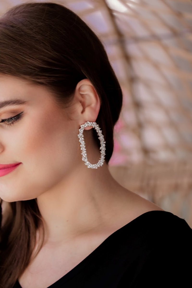 gold cubic zirconia earrings secured with a push backing in a long oval shape in crystal