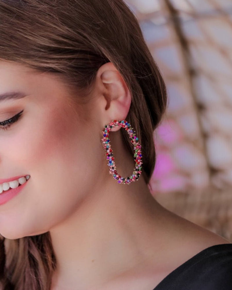 gold cubic zirconia earrings secured with a push backing in a long oval shape in multi