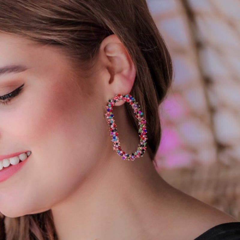 gold cubic zirconia earrings secured with a push backing in a long oval shape in multi