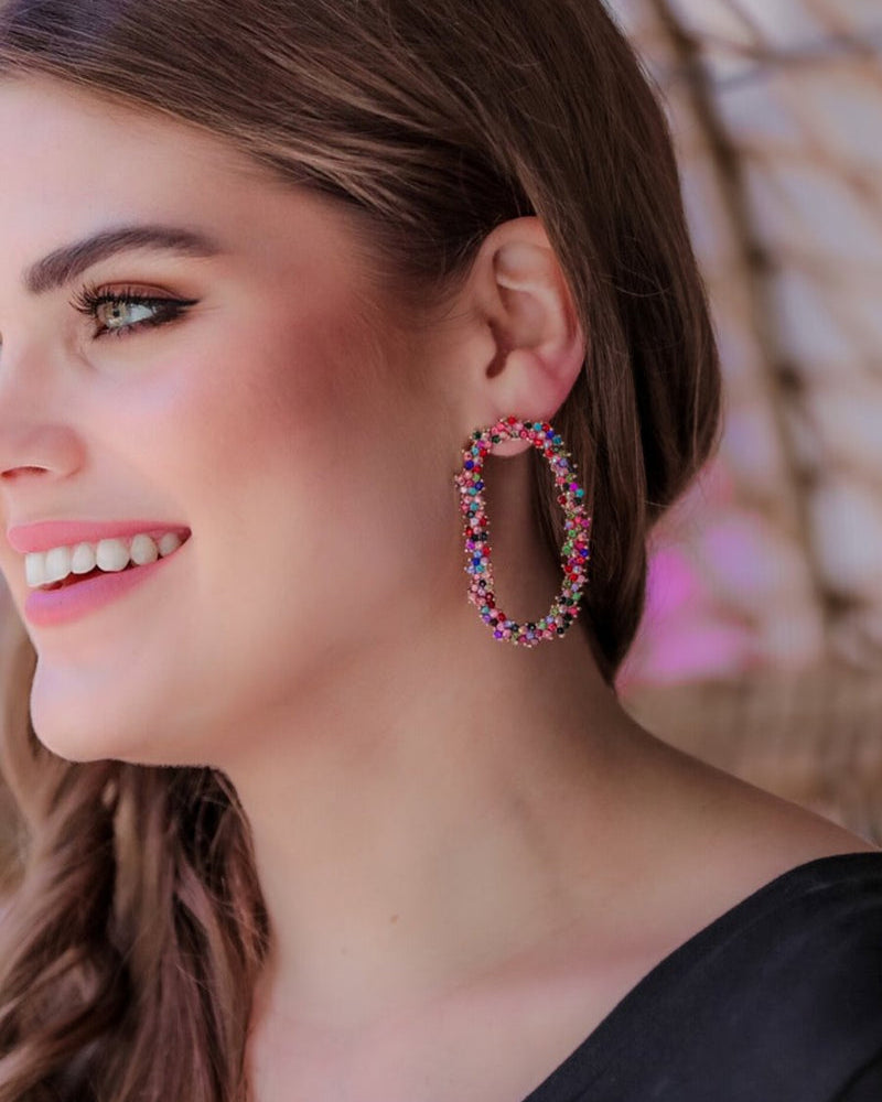 gold cubic zirconia earrings secured with a push backing in a long oval shape in multi