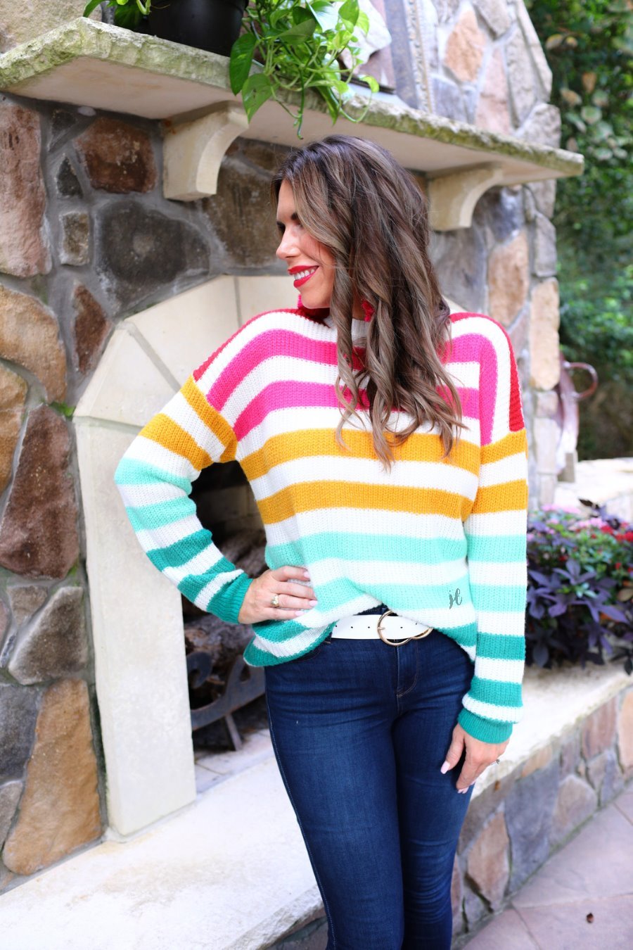 a textured knit long-sleeve sweater with a vibrant colorful stripe pattern (burgundy, magenta, mustard, teal, and forest green), a relaxed drop-shoulder fit, classic crew neckline, and ribbed detailing on the cuffs, neckline, and hemline on an ivory base