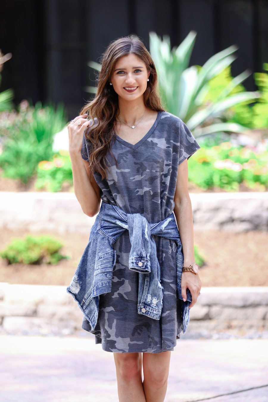 an oversized grey A-line pocket dress with a V-neckline, short sleeves, side pockets, a curved hem, and a terry cloth texture