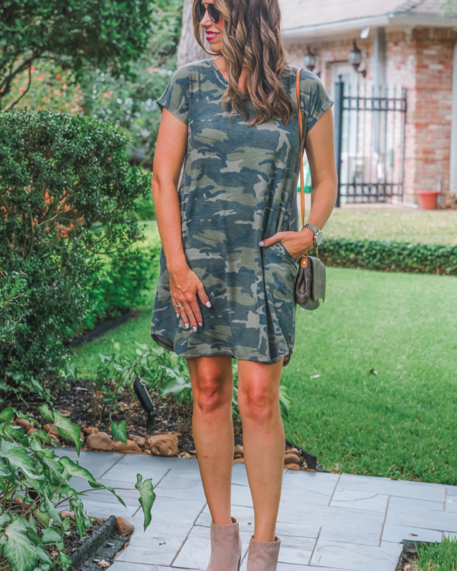 an oversized green A-line pocket dress with a V-neckline, short sleeves, side pockets, a curved hem, and a terry cloth texture